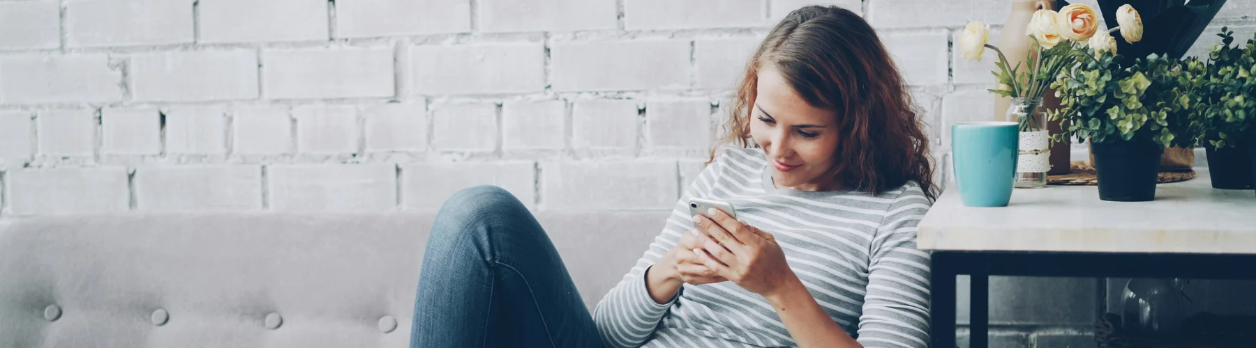 Vrouw scrolt ontspannen op haar smartphone in de zetel